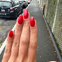 Bright red manicure on long almond-shaped nails